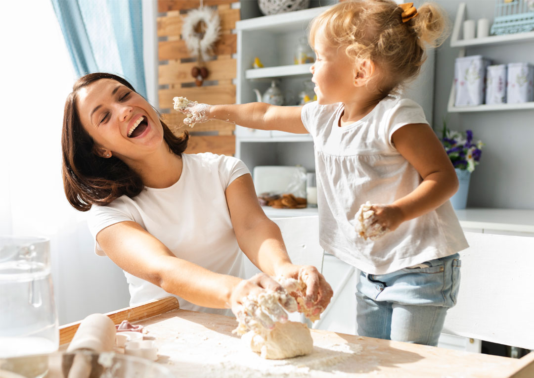 mãe e filha brincando na cozinha com receita culinária