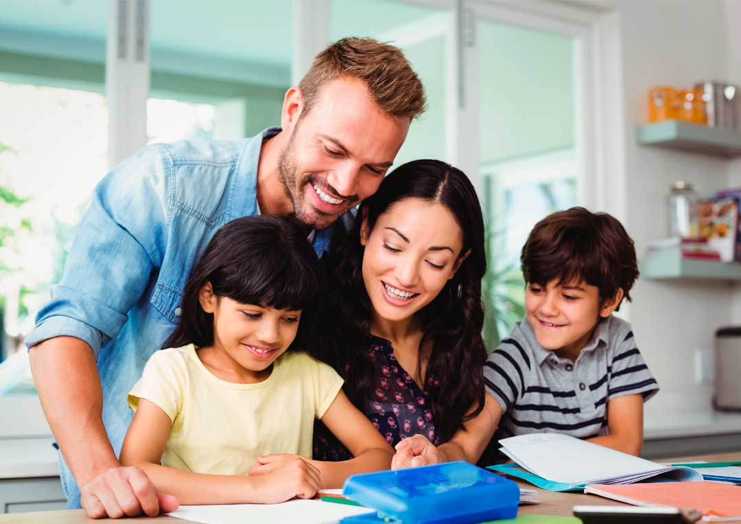 pai e mãe ajudando filhos na lição de casa