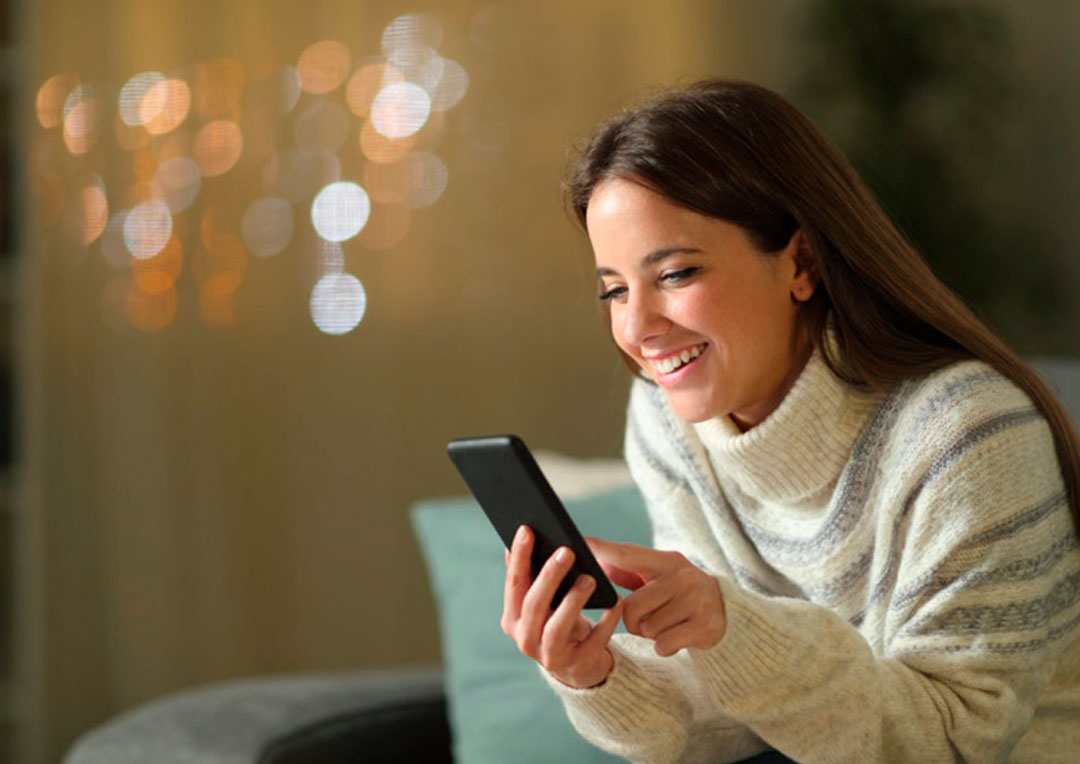 menina sorrindo olhando o celular