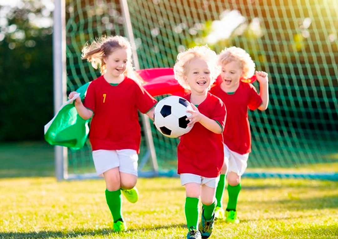 três crianças brincando juntas com uma bola